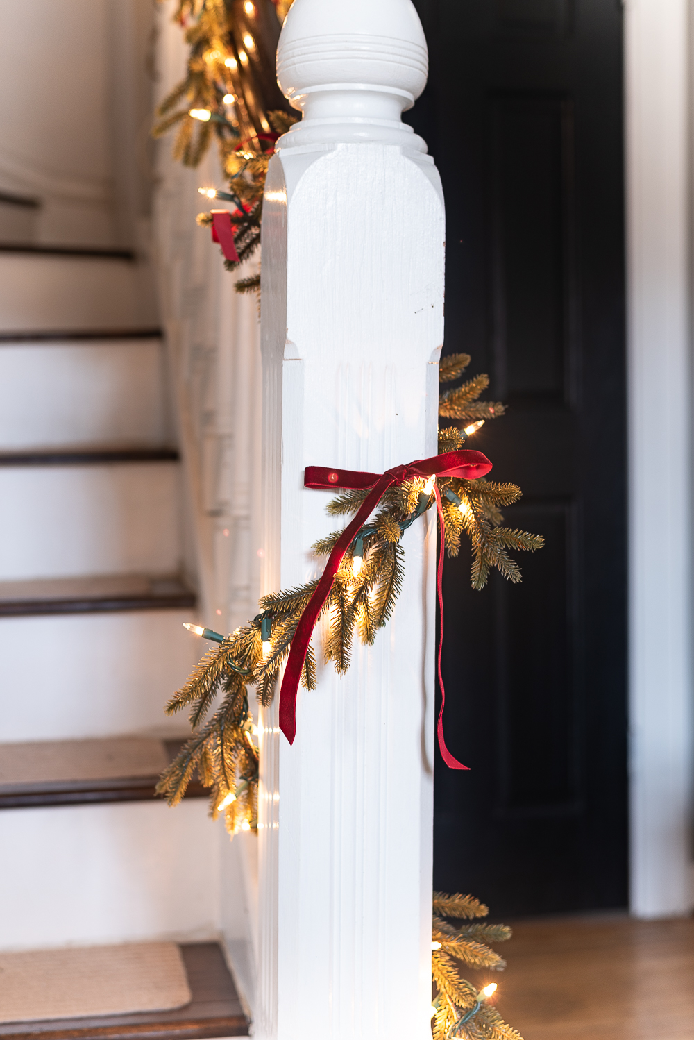 Red, White, Green Christmas Entry Decorating Ideas - Red Velvet Bow on Wreath - Lighted Garland with Red Velvet Bows on Staircase - Decorating Ideas for Entry for Holidays